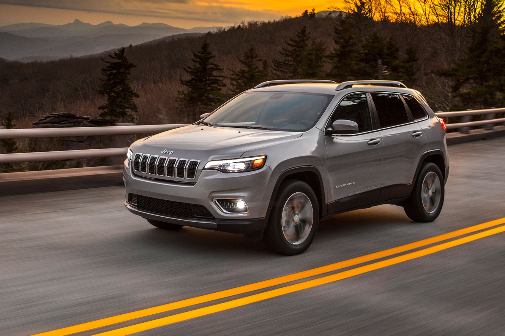 grey Jeep Compass driving on a mountain road